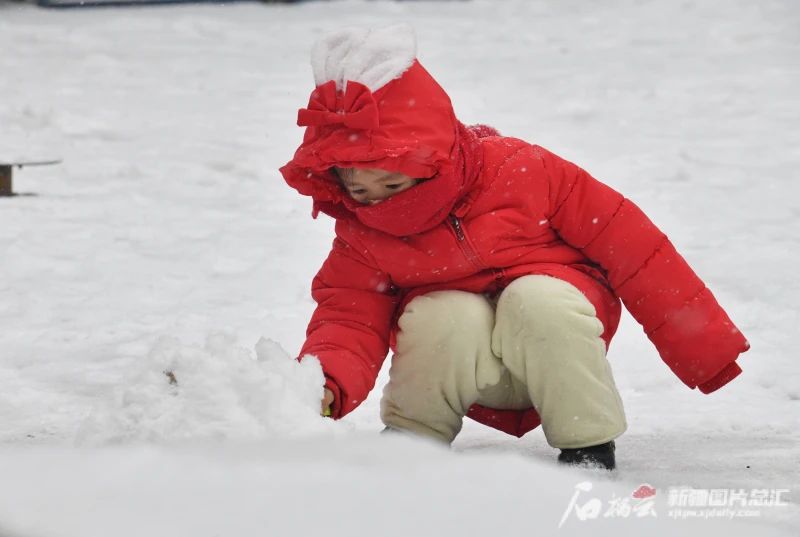 12月9日，乌鲁木齐市一位小朋友在玩雪。石榴云 新疆日报记者张新军摄